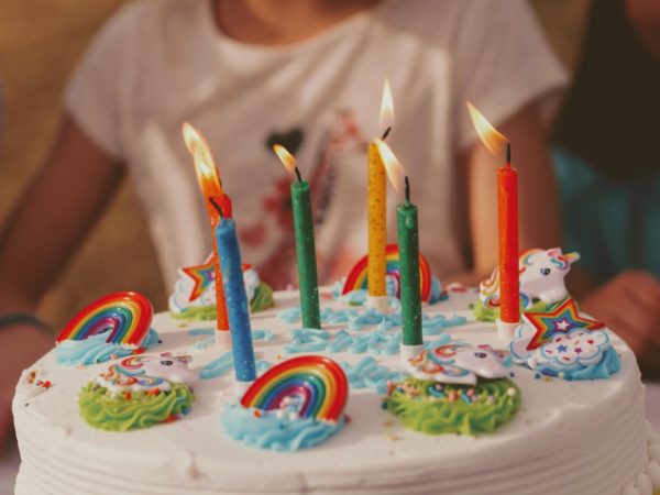 Barn med kake med regnbue-pynt